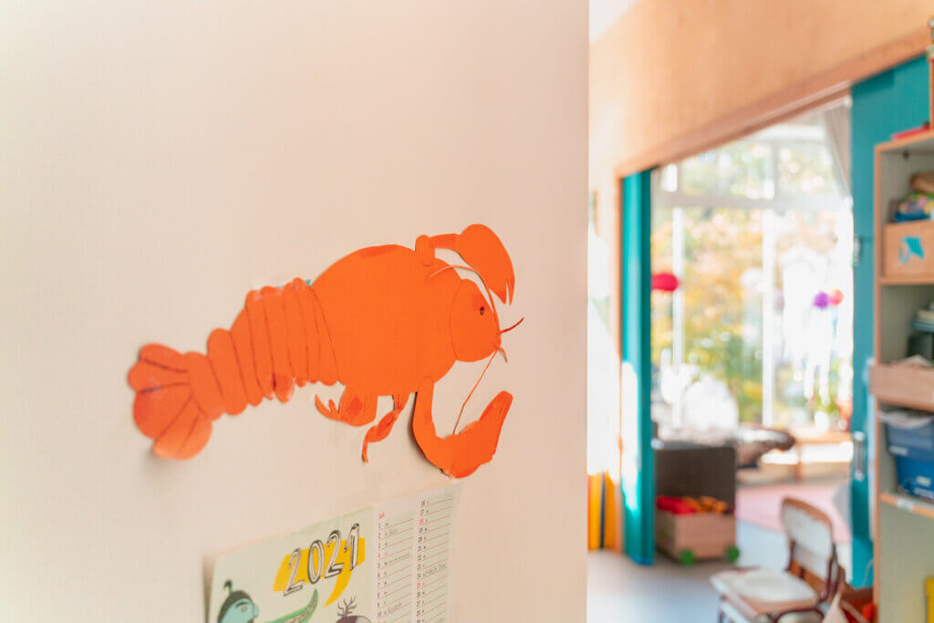 Papier-Hummer an der Wand der Kita