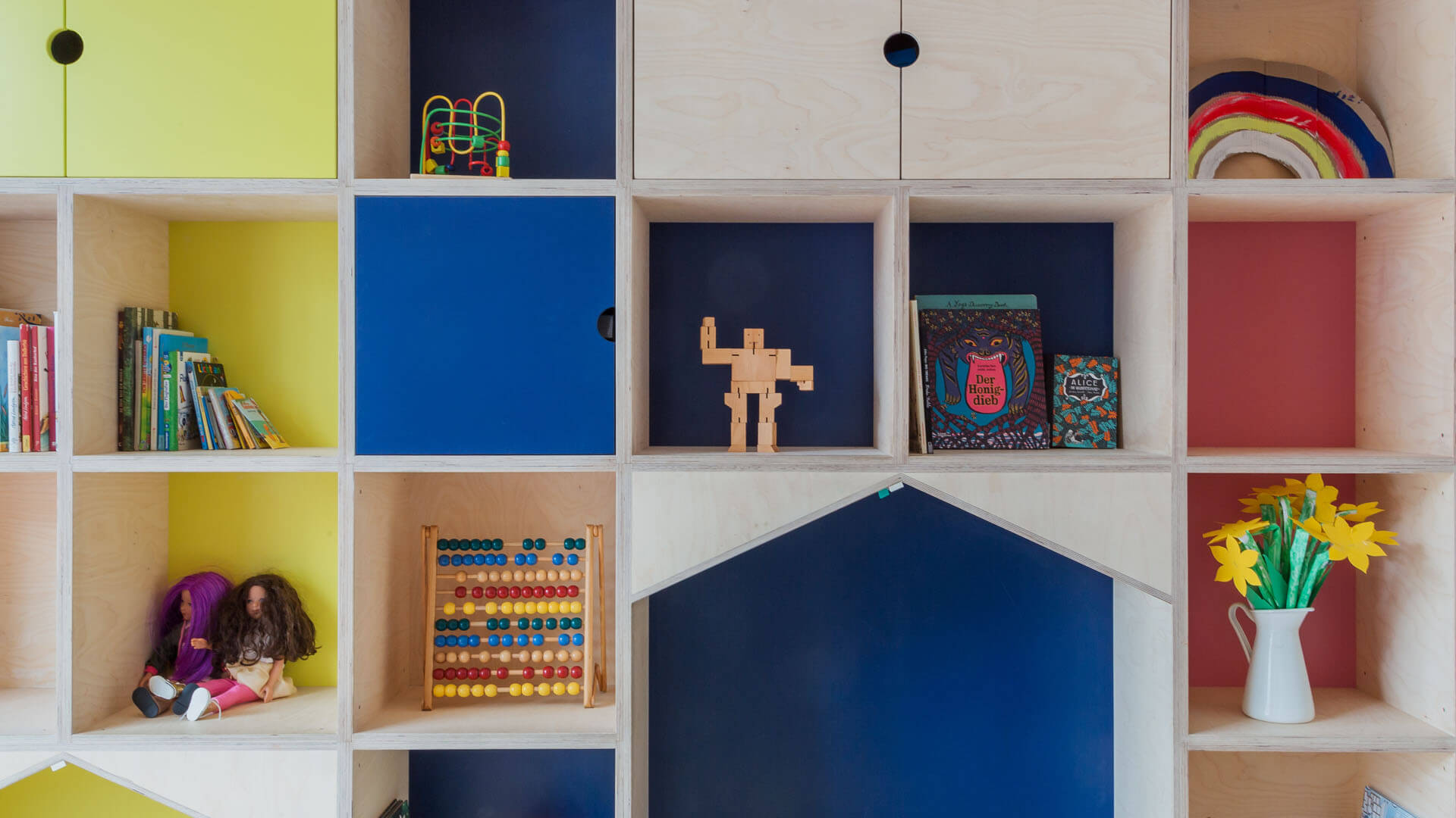 Regalwand mit Büchern und Spielsachen in der Kita